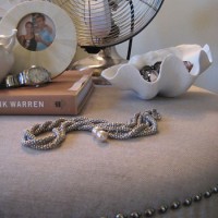 Using A Nailhead Ottoman As A Side Table In The Bedroom