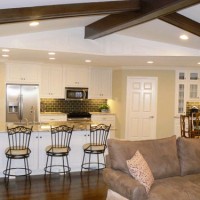 A Living Room With Painted Paneling And Wood Beams