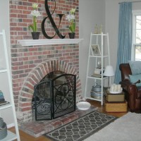 A Family Room With A Brick Fireplace And Blue Curtains