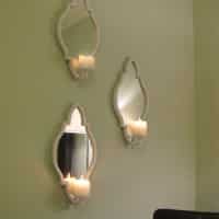 Three Candle Sconces On The Bedroom Wall