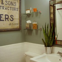 A Sage Green Bathroom With Orange Accents