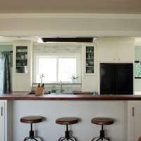 A Kitchen With Glass Cabinets, Wood Counters & A Marble Backsplash