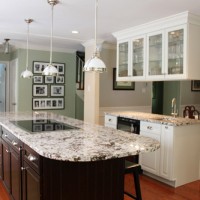 A Classic Kitchen With A Granite Island And White Glass Cabinets