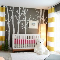 A Dark Gray Nursery With A Tree Mural & Striped Curtains