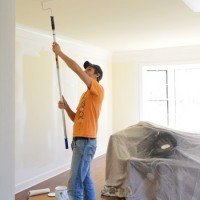 John Rolling Paint On Ceiling Of Office With Pole