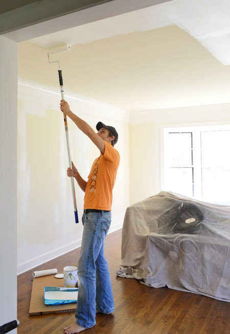 John Rolling Paint On Ceiling Of Office With Pole