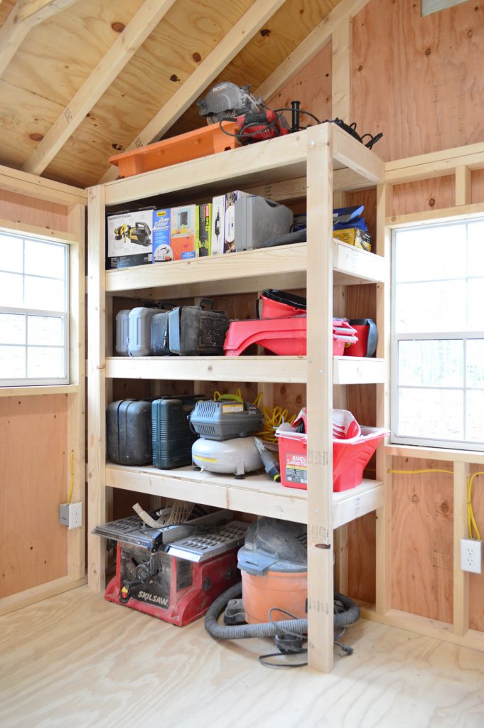 finished garage shelves in unfinished shed with tools and saws
