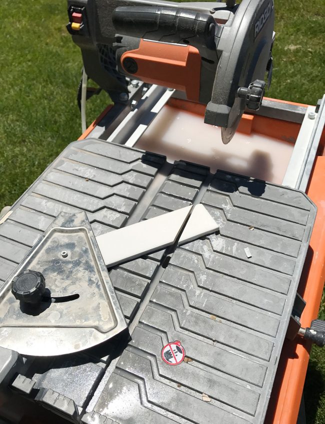 wet saw being used to cut a 45 degree angle on single subway tile