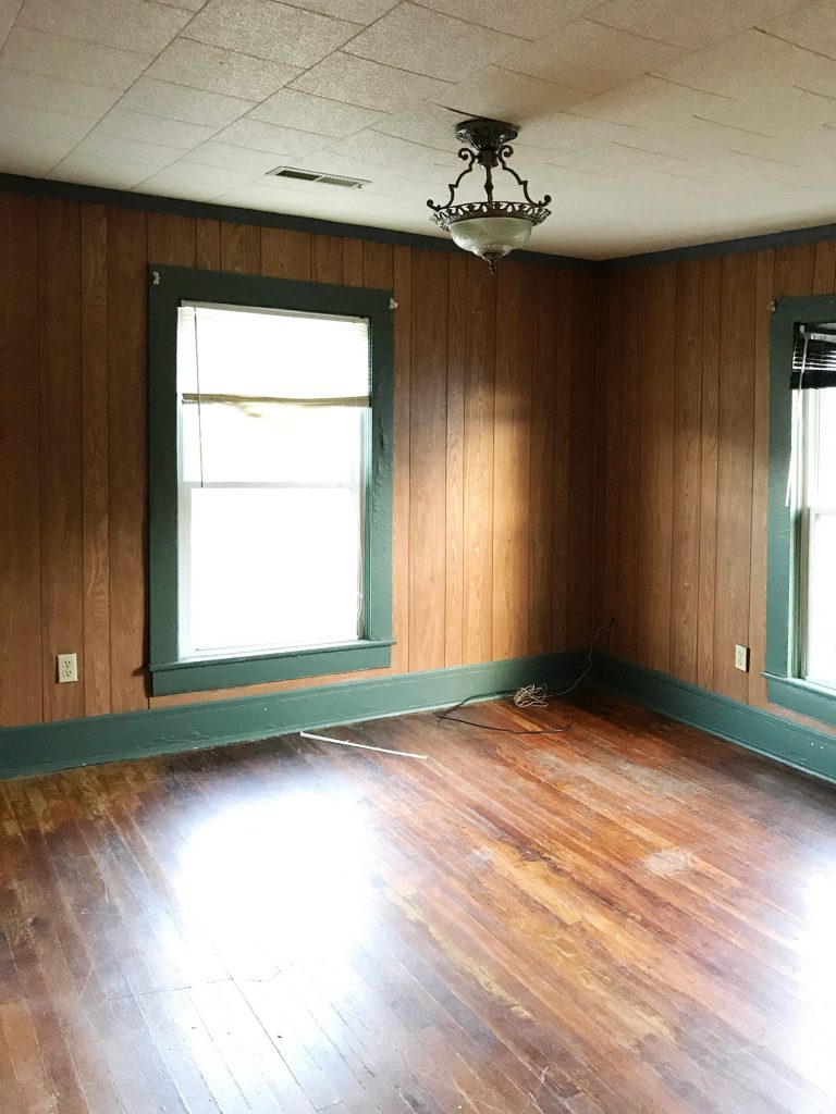 Before Photo Of Front Bedroom With Wood Paneling And Green Trim