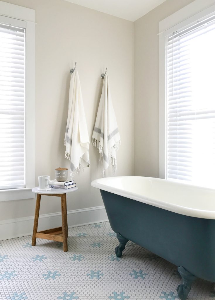 White bathroom with navy blue refinished clawfoot tub