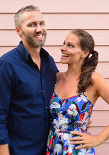 John and Sherry smiling against pink background