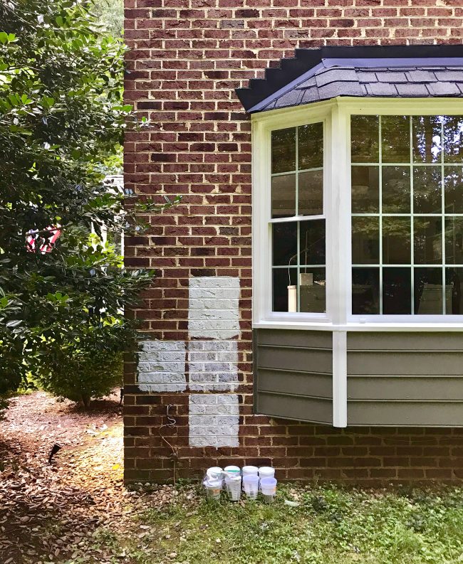 sample sections of white paint on brick house