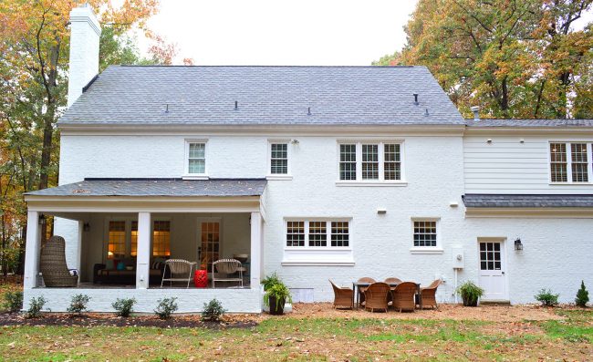 After View Of White Brick Painted Colonial Home With Covered Porch