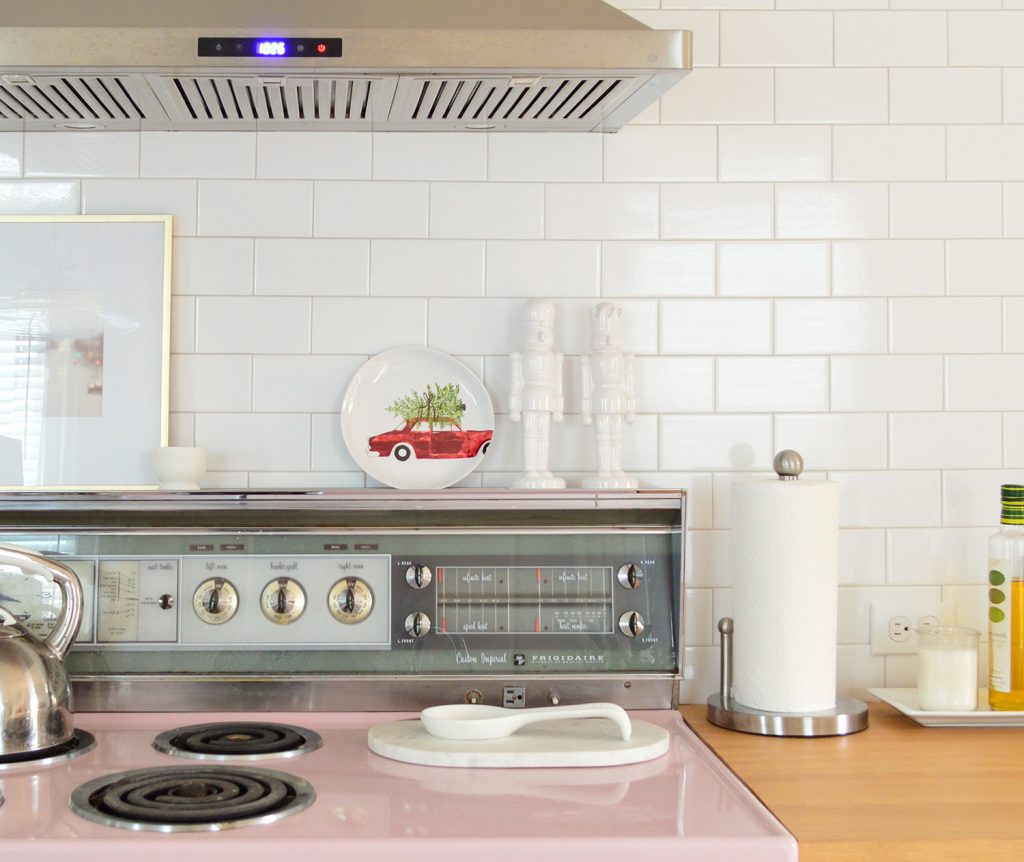 Retro Pink Stove In Kitchen With White Subway Tile And Christmas Plate