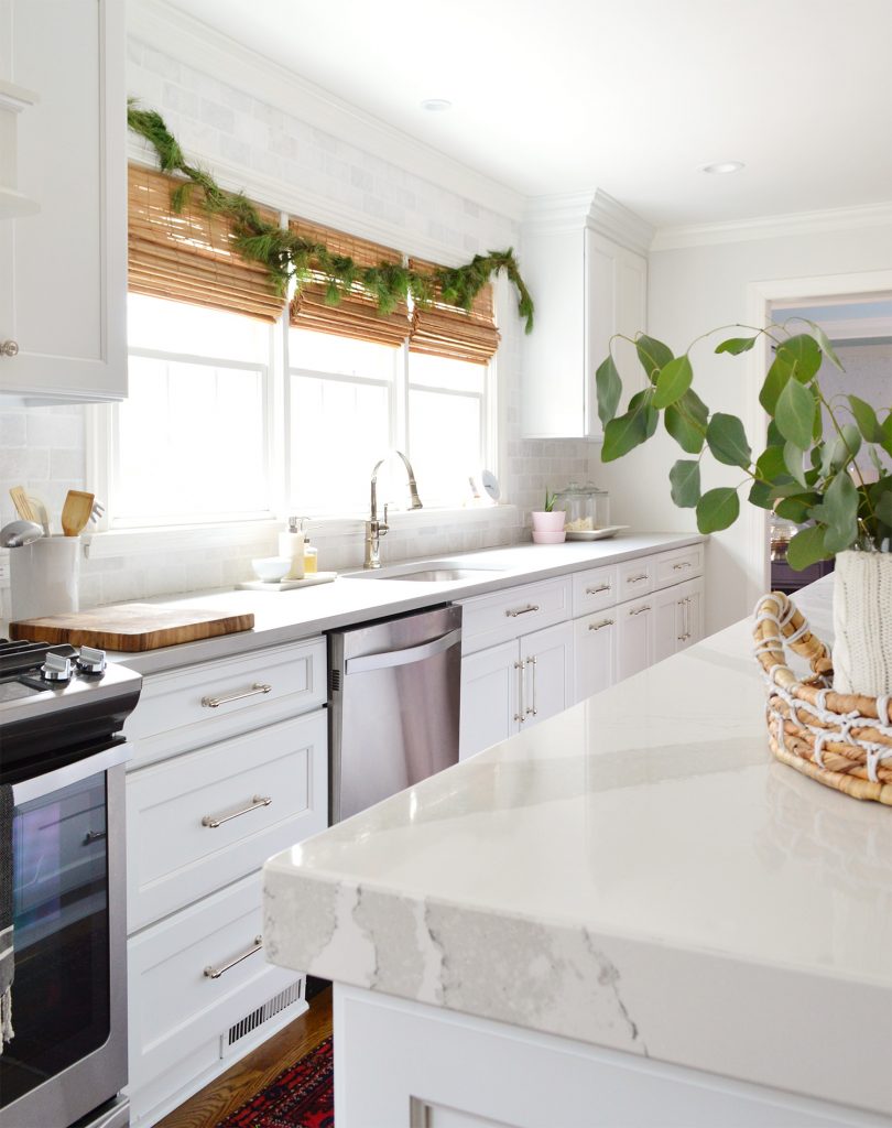 White Kitchen With Holiday Fir Garland Over Sink Windows