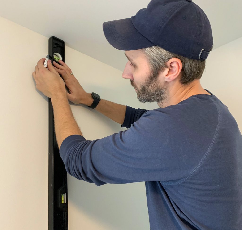 Drawing Vertical Level Line Before Hanging First Panel of Wallpaper