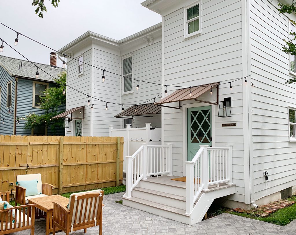 After Photo of Duplex Backyard With Metal Tin Awnings | Wood Fence | Patio | Outdoor Showers