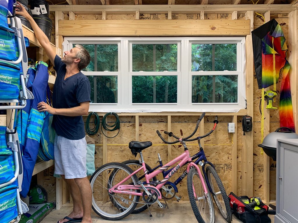 John reaching for something in beach house shed