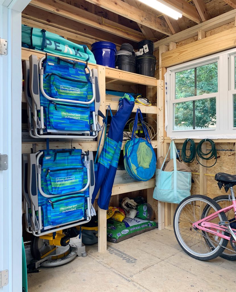 Beach gear hanging on large rubber hooks on the front of heavy duty storage shelves