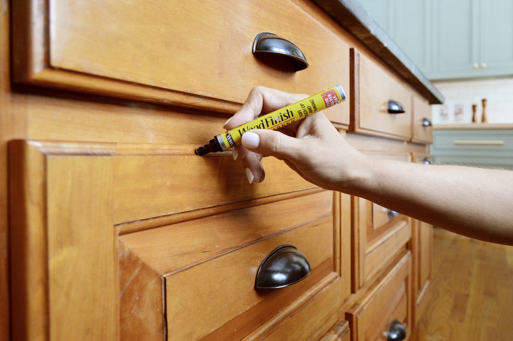 Sherry Applying Stain Marker To Wood Cabinets