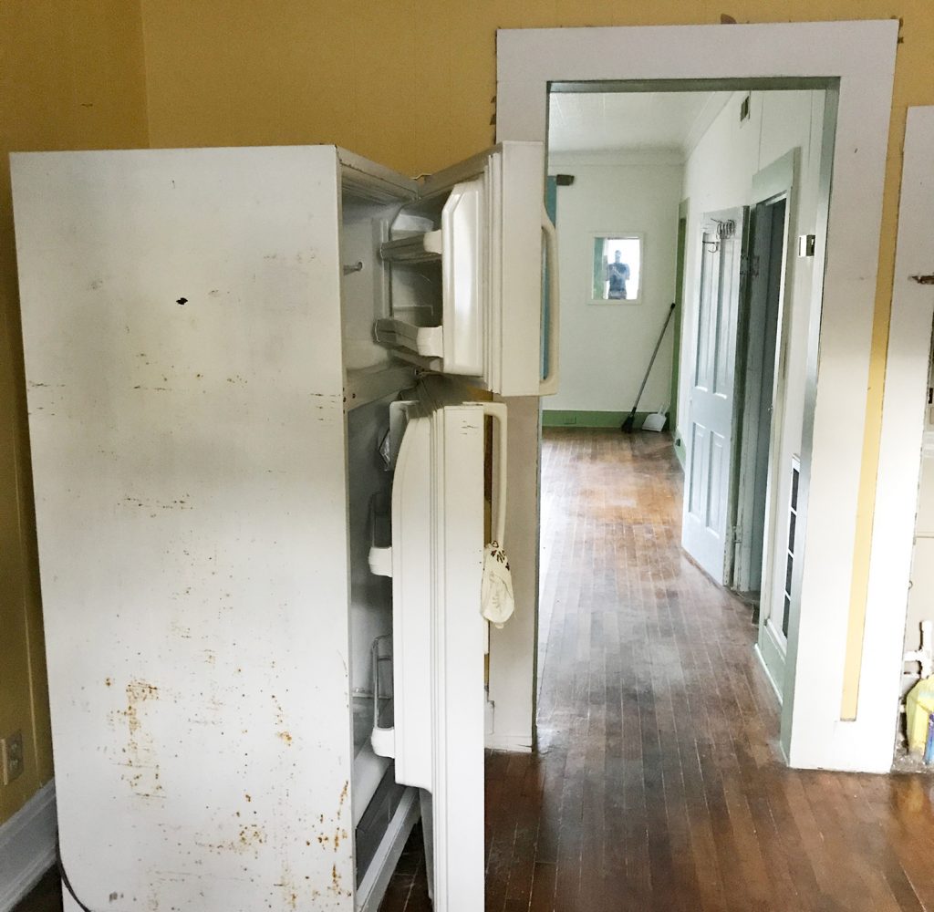 Before Photo Of Kitchen With Rusted Refrigerator In Middle Of Room