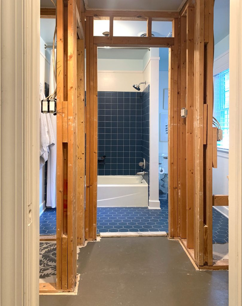Demo Photo Of Drywall Down Exposing Space Between Vanity And Shower In Old Bathroom