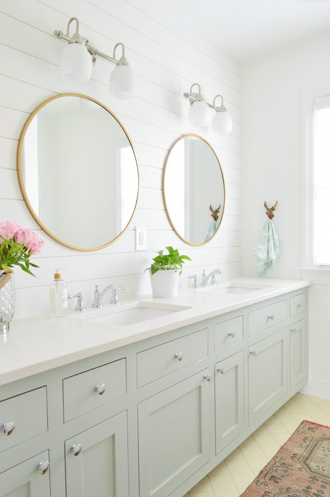 After Photo Of Hall Bathroom With White Shiplap Walls and Green Painted Double Vanity With Round Mirrors