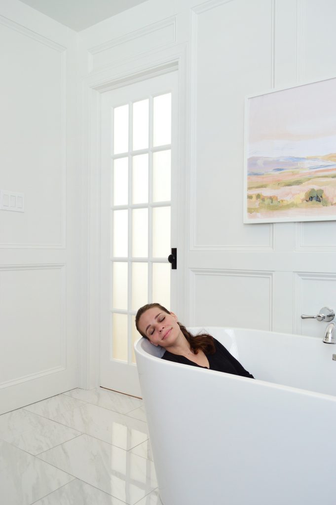Sherry Sitting In Freestanding Tub In Modern Traditional Bathroom With Marble Floor And Wall Molding