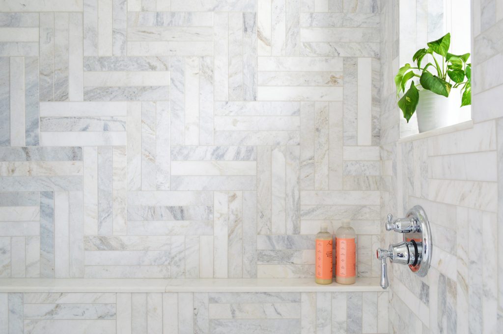 Detail Of Marble Herringbone Pattern Along Wall of Walk In Shower With Ledge