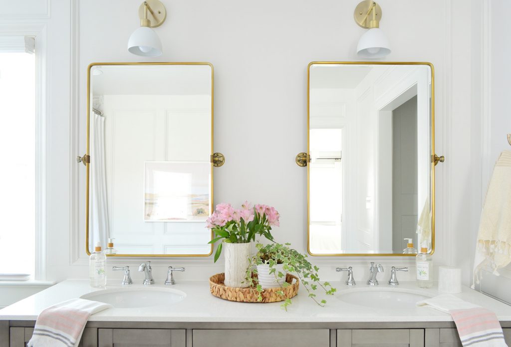 Brass Pivot Mirrors Over Double Vanity With Traditional Moldings And Shades Of Light Dapper Sconces