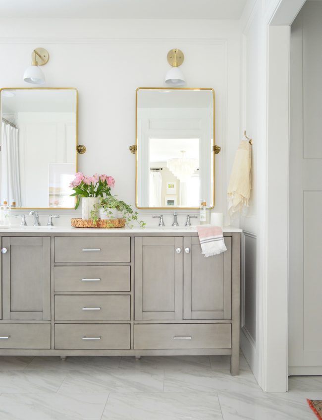 Gray Double Vanity In Marble Bathroom With Brass Pivot Mirrors And Dapper Shades Of Light Sconce