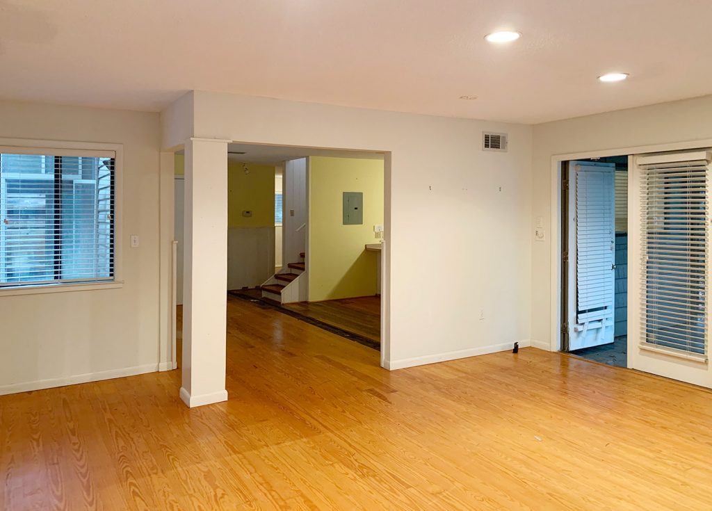 Before photo of living room turned bedroom with open wall to kitchen