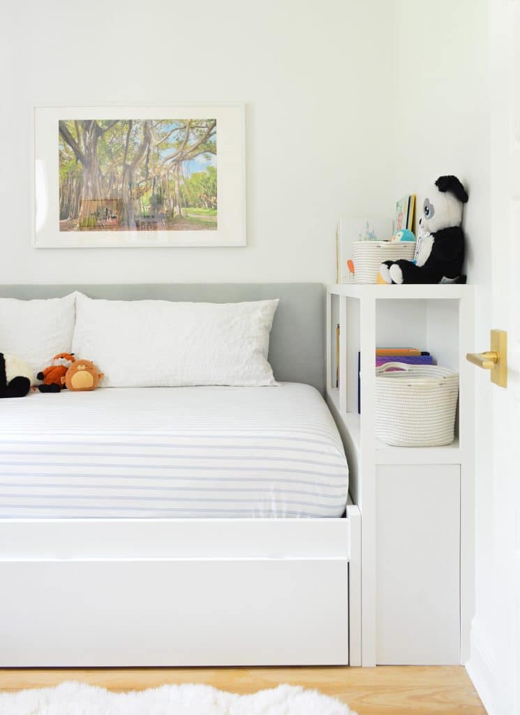 Boys bedroom with fabric headboard and built-in bed with bookcase footboard