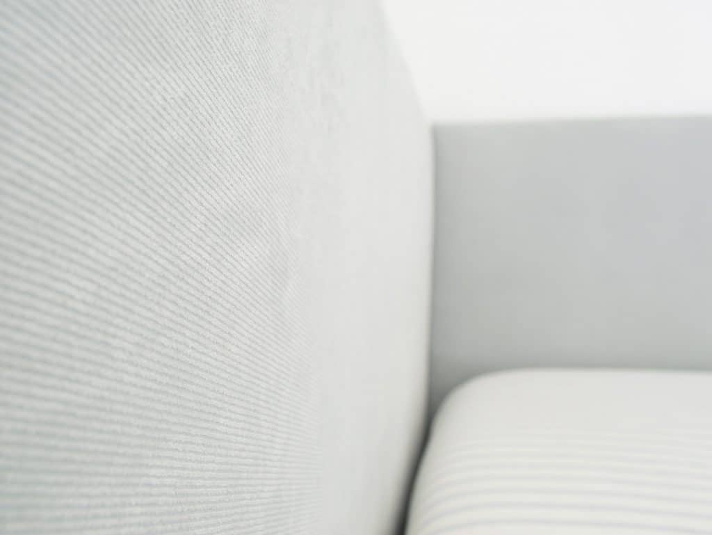 Fabric detail on DIY upholstered headboard with subtle blue ribbing