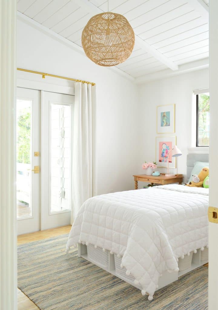 Girls bedroom with vaulted plank ceiling and woven light fixture
