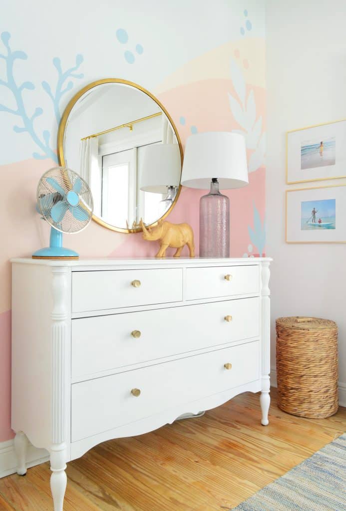 Beachy abstract mural in girls bedroom with traditional dresser and gold mirror