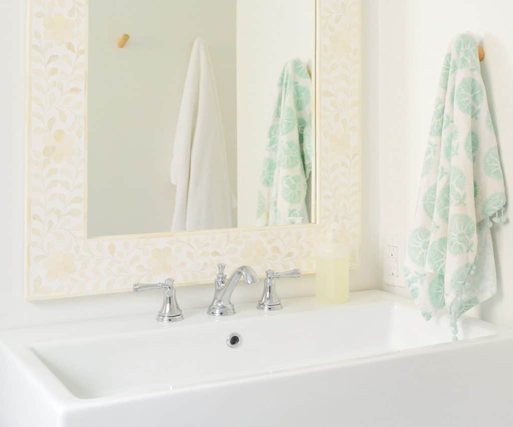 Bright modern bathroom with large white sink and bone inlay mirror