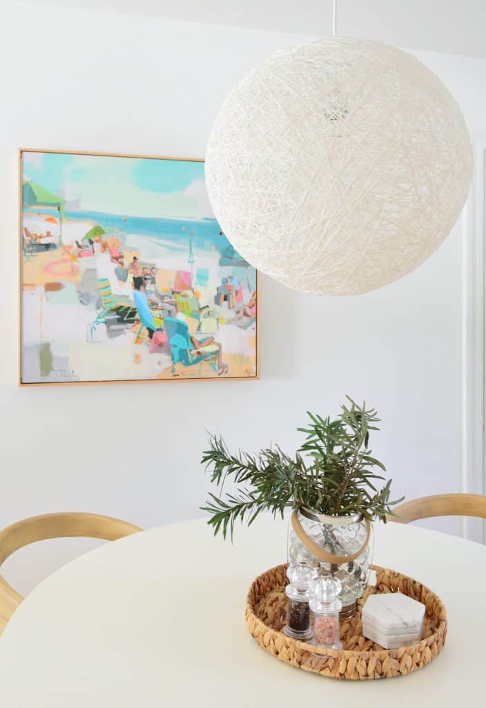 Close Up Of Woven White Pendant Light From Pottery Barn Teen Over Table With Beachy Art