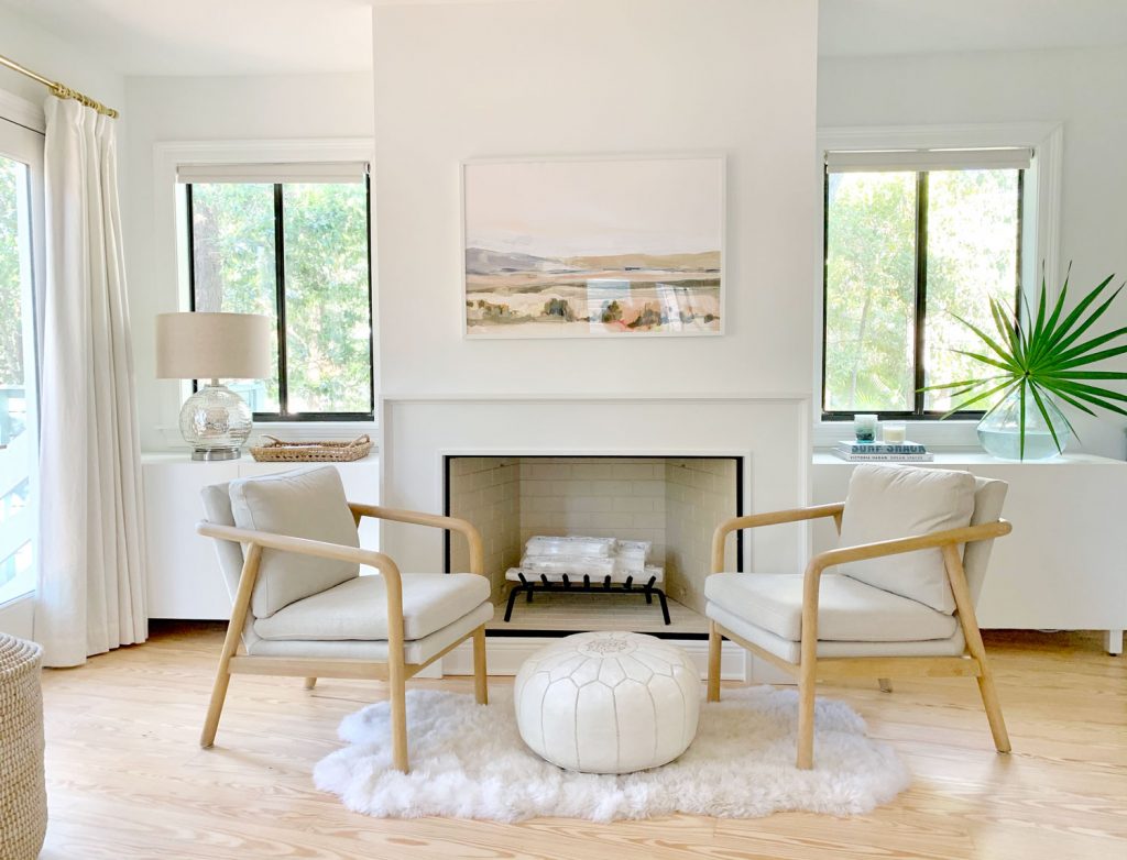 Bedroom fireplace view with two chairs and Ikea Besta cabinets sitting on either side of fireplace