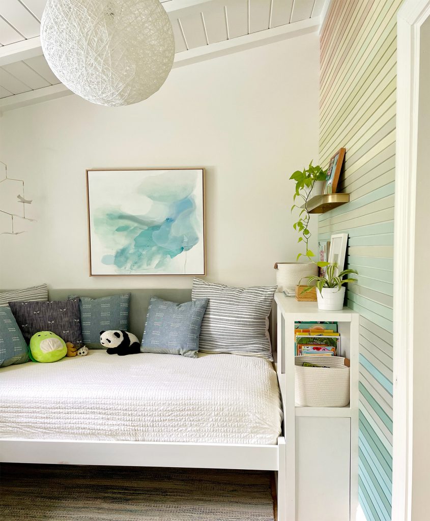 Built-In Bookcase Next To Bed With Upholstered Headboard In Kids Room With Vaulted Ceiling