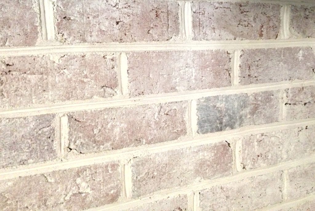 close up detail of brick wall fireplace with a DIY whitewash treatment applied