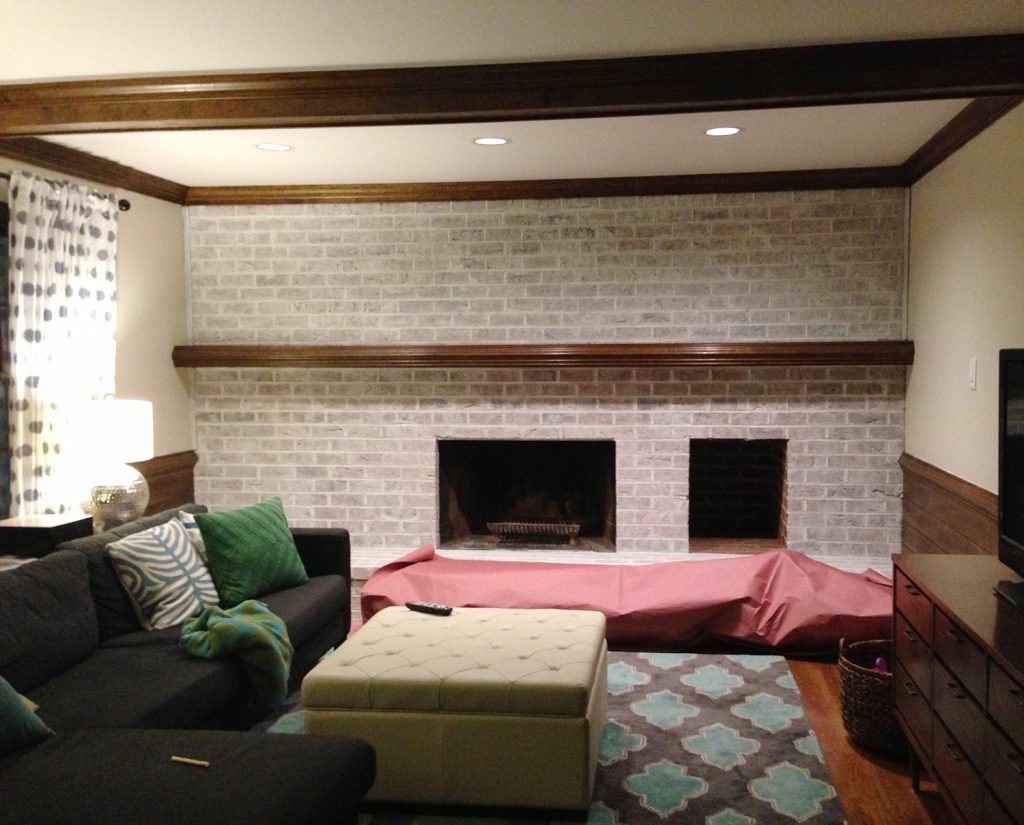 lightly whitewashed brick wall in living room with fireplace and mantle using leftover white paint