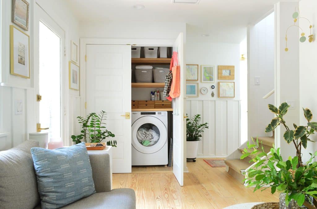 One Door Open In Open Laundry Closet Behind Seating Area In Kitchen