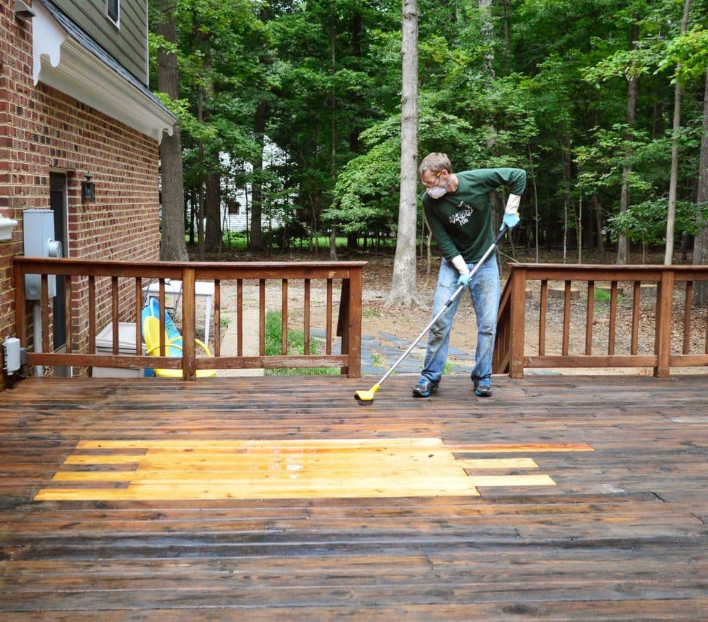 John scrubbing wood deck with deck brightener cleaner