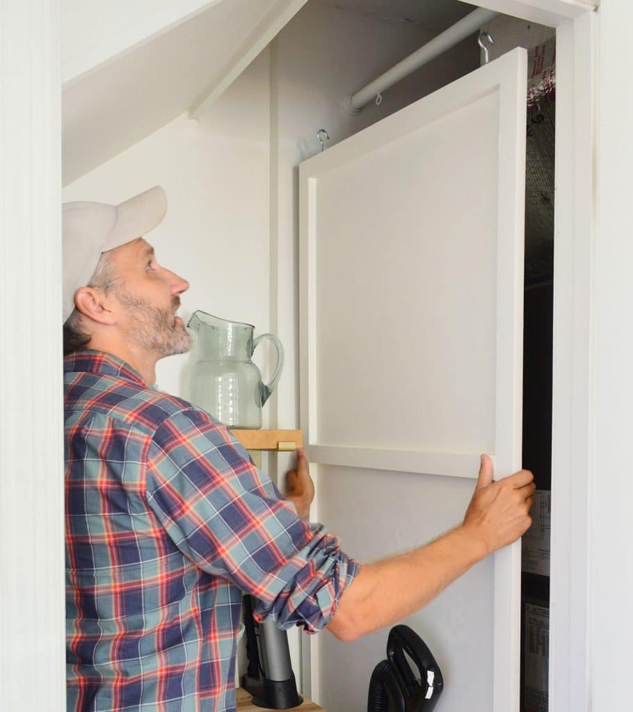 John Lifting HVAC Cover Panel Off Of Hanging Rod