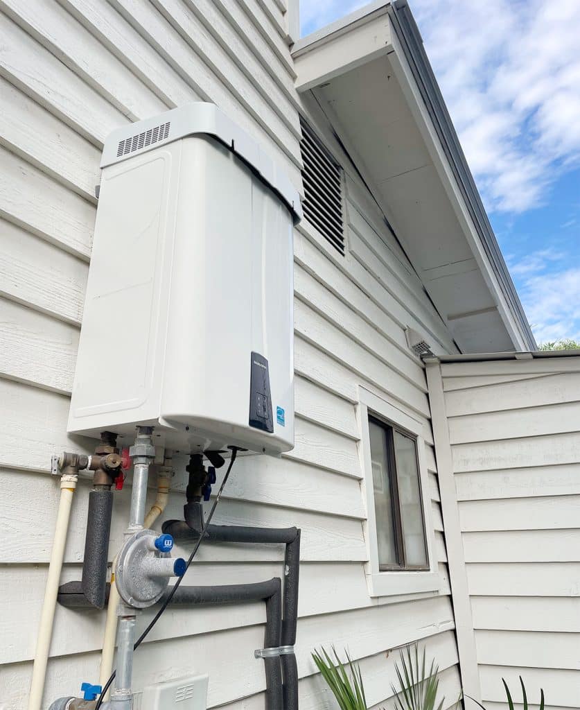 Outdoor gas water heater mounted to the siding of Florida home