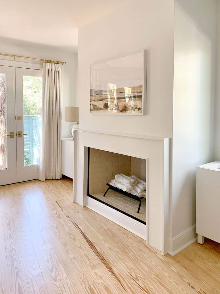 A modern white fireplace and IKEA Vesta storage cabinets flanking either side