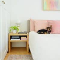 Wood Butcher Block Nightstand Next To Bed With Penny The Chorkie Sleeping On Pink PIllow
