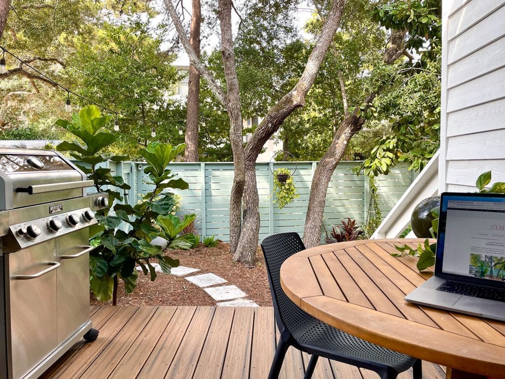 View Of Kitchen Porch With Outdoor Grill And Table With Laptop On It