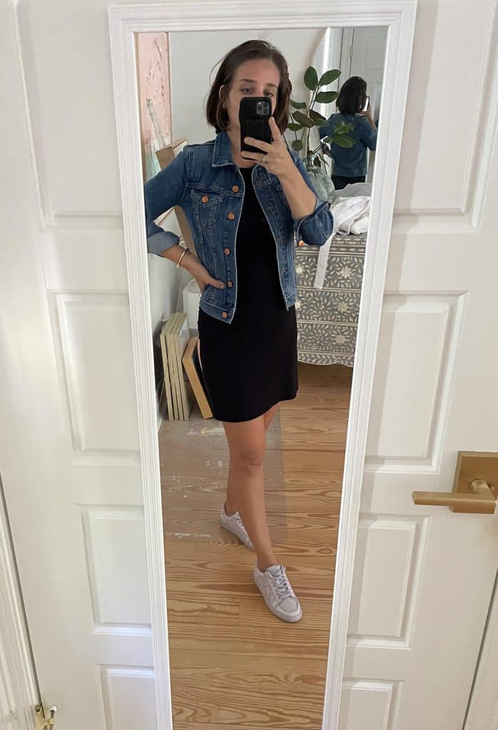 Sherry selfie in mirror at home with short black dress and jean jacket and tennis shoes